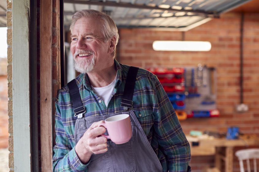 portrait-of-senior-male-wearing-overalls-in-garage-2023